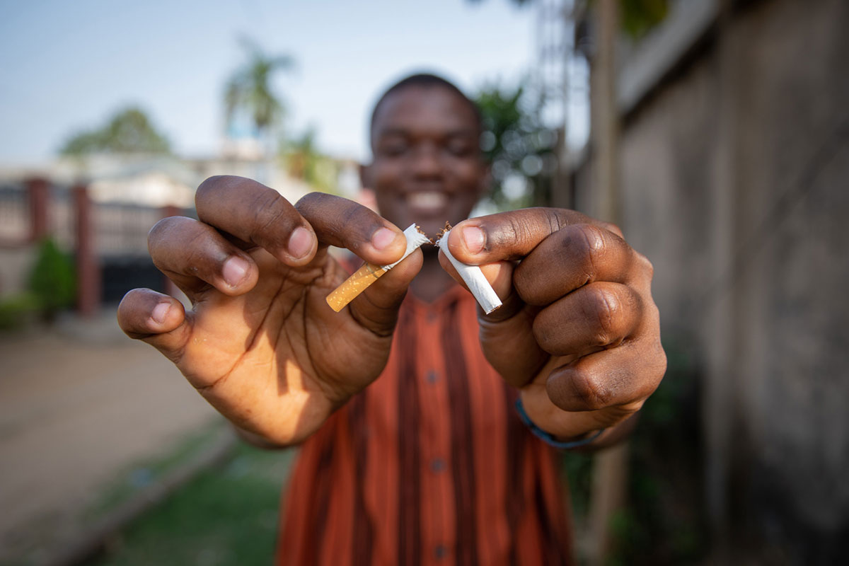 african american man breaking a cigarette in half